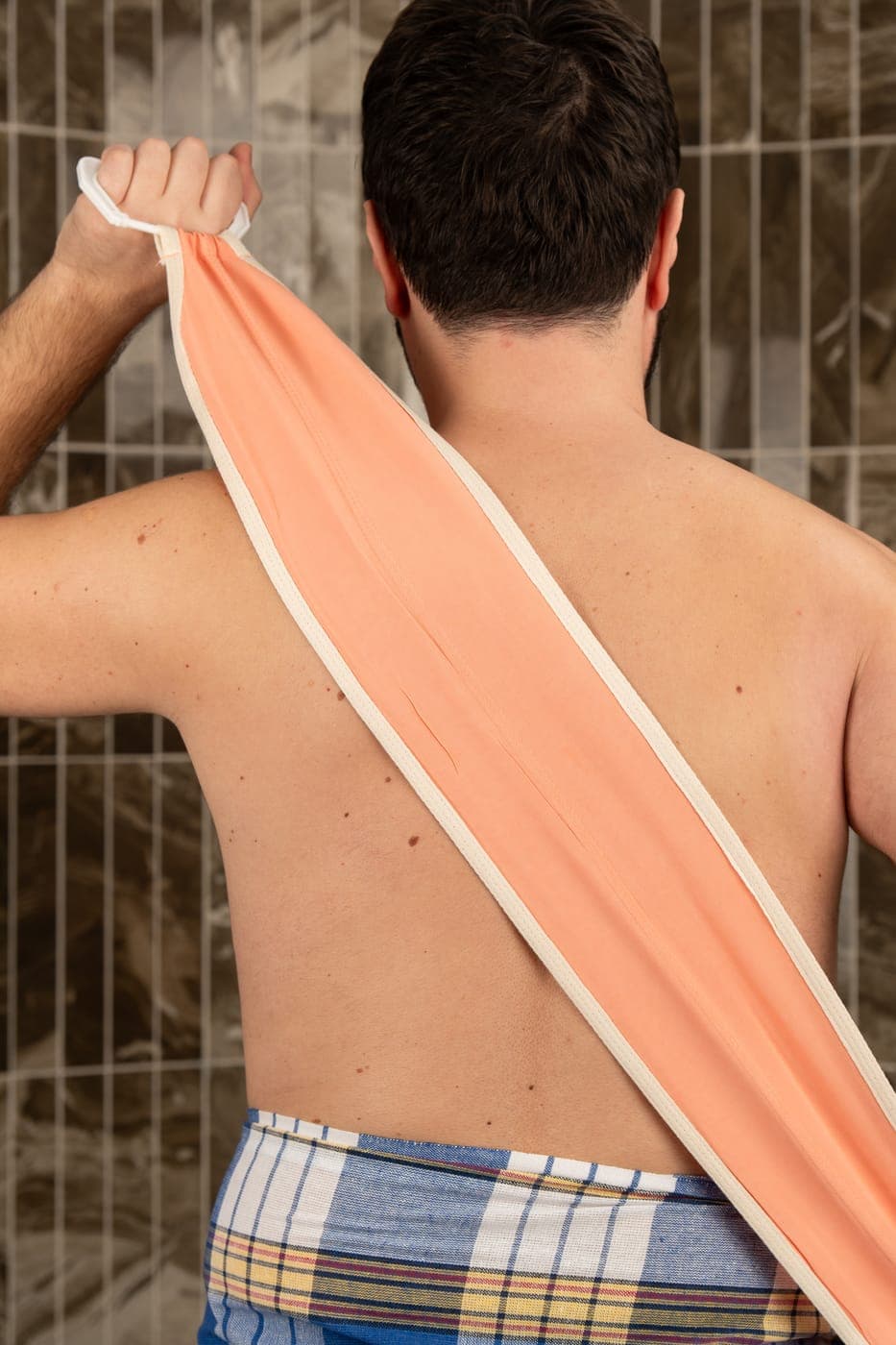 Close-up of the salmon pink vegan plant silk back exfoliator strap, woven from plant-based fibre