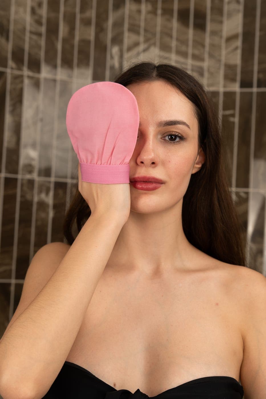 Candy pink vegan plant silk face exfoliating mitt held close, woven from plant-based fibre