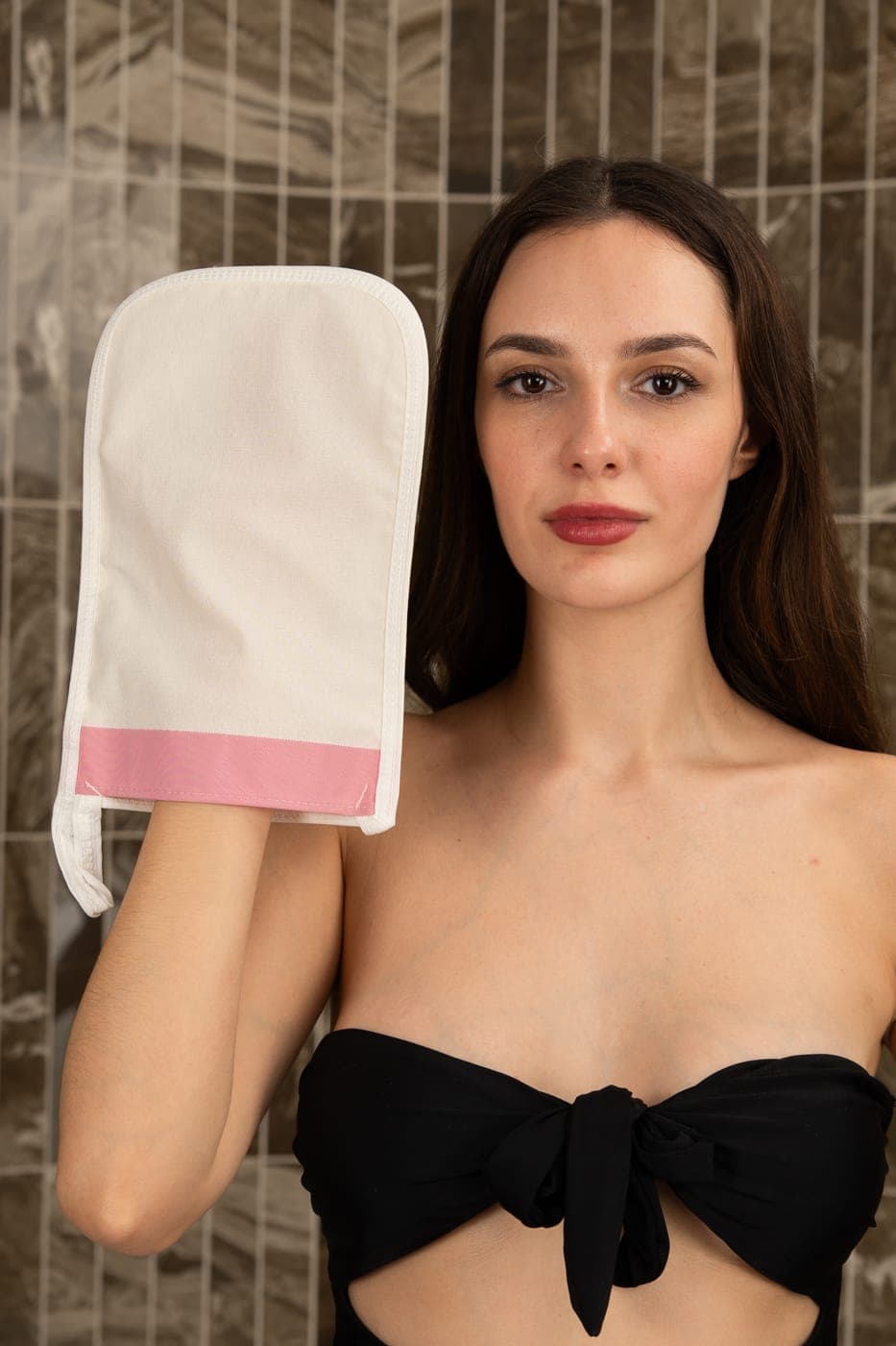Close view of the natural cross-stitch viscose Turkish kese exfoliating glove with pink trim